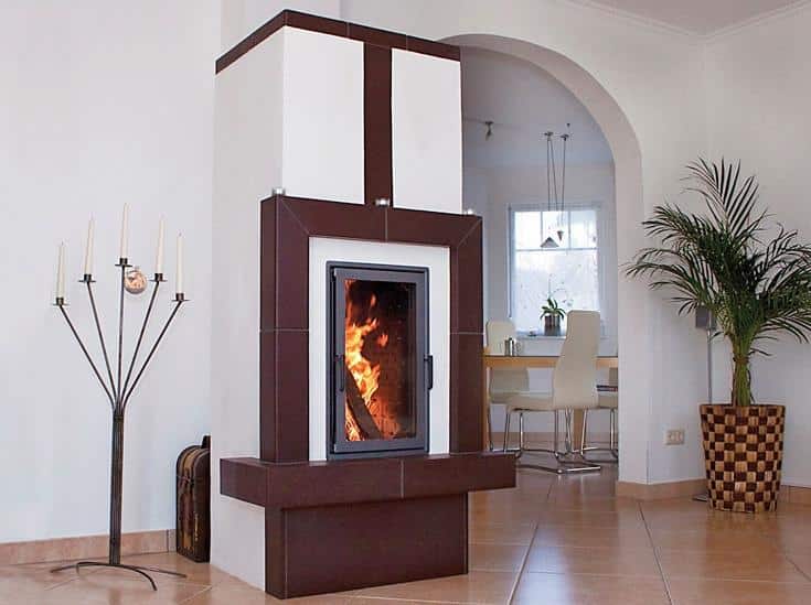 Moderner Speicherofen mit braun-weißer Verkleidung in elegantem Wohn-Essbereich mit Rundbogen und Fliesenboden