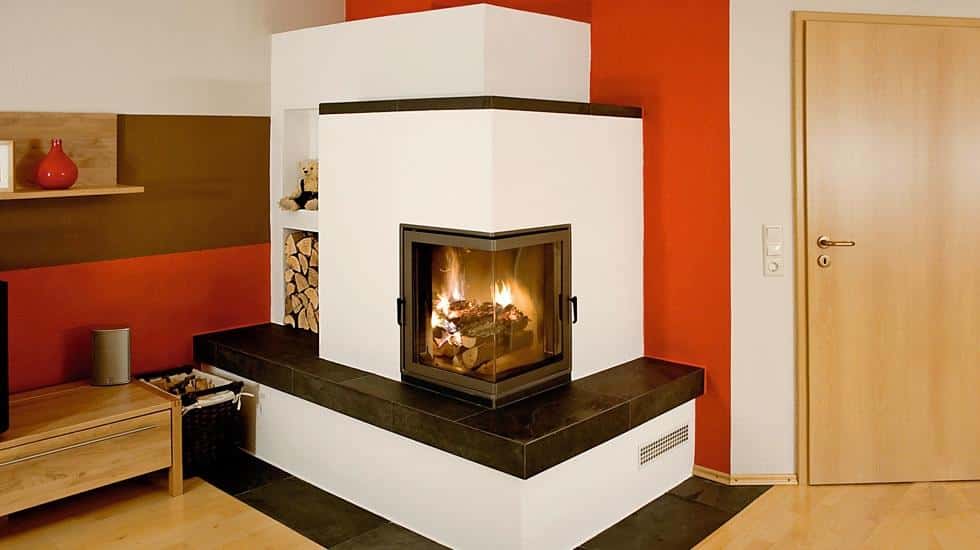 Eckkamin mit Holzbank und integriertem Holzfach in modernem Wohnzimmer mit roten Wandakzenten