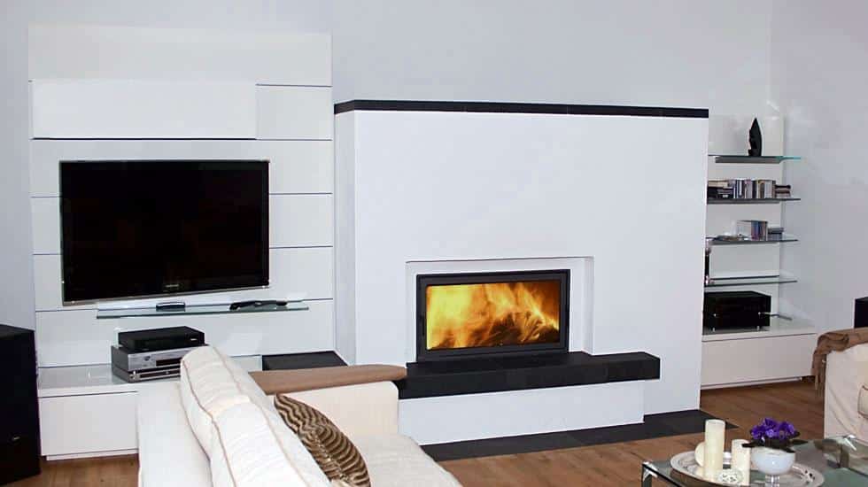 Moderner Speicherofen mit horizontaler Sichtscheibe in minimalistischem Wohnzimmer mit TV-Wand und Glaselementen