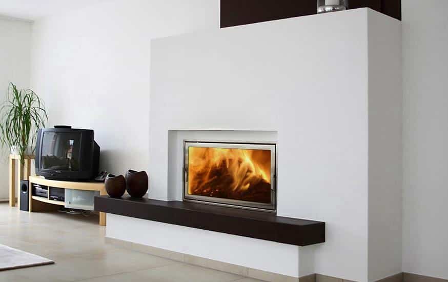 Moderner Kamin mit breiter Sichtscheibe und dunkler Holzbank in hell gestaltetem Wohnzimmer mit TV-Ecke