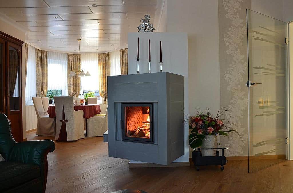 Moderner Hängekamin mit grauer Verkleidung im klassischen Wohnambiente