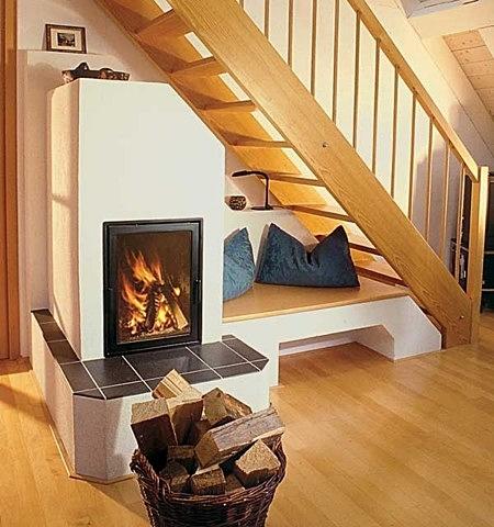 Speicherkamin unter Treppe mit integrierter Sitzbank und Holzeinsatz