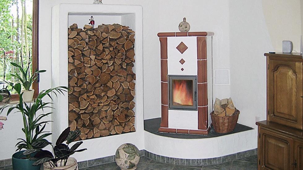 Speicherkamin mit rötlich-brauner Keramikverkleidung und integriertem Holzlager