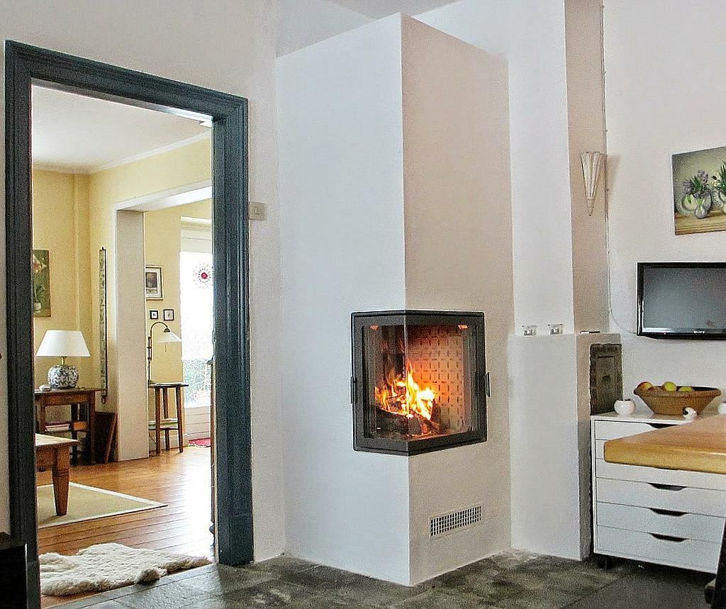 Schlichter Speicherkamin mit Glastür in klassischem Altbau