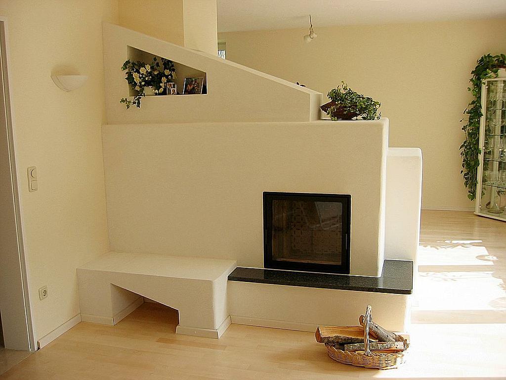 Speicherkamin mit schräger Wandnische, integrierter Sitzbank und heller Raumgestaltung