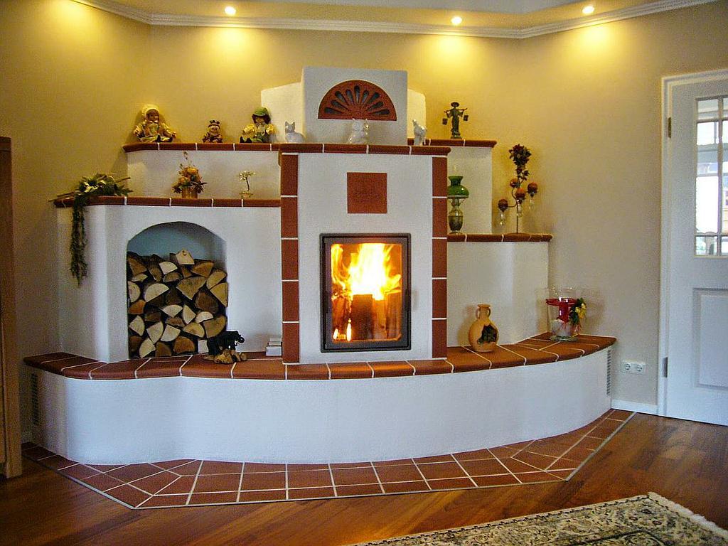 Traditioneller Speicherkamin mit rotem Kacheldekor und Holzlager, verziert mit Figuren und Deko-Elementen